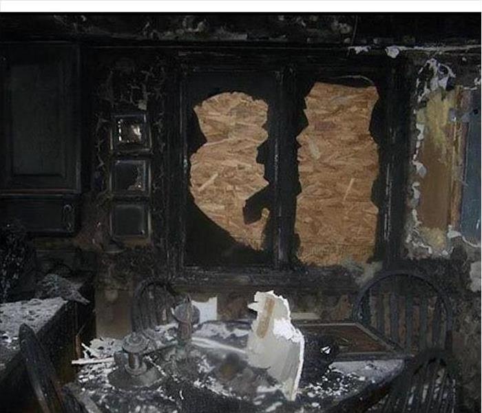 severe fire damage in a kitchen, cabinets totally burned
